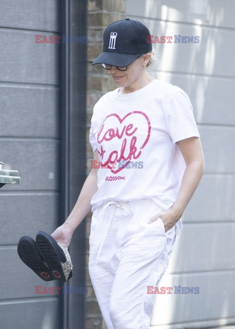 Kylie Minogue niesie buty w ręku