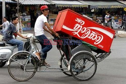 DOSTAWCA JADACY NA ROWERZE WIEZIE DYSTRYBUTOR (AUTOMAT) O COCA COLI. HO CHI MIN CITY (SAIGON), VIET NAM