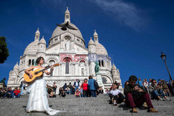 Śpiewa w ślubnej sukni na ulicach Paryża - AFP