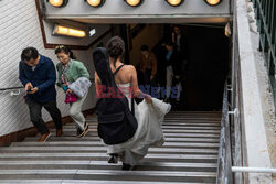 Śpiewa w ślubnej sukni na ulicach Paryża - AFP